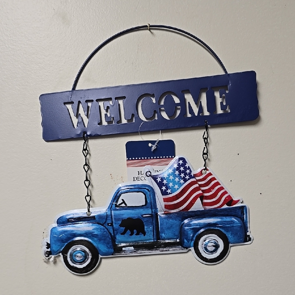 Blue Welcome Sign with Truck and Flags